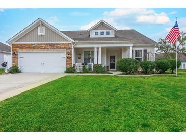 Charming single-story home featuring a well-manicured lawn and a welcoming front porch with decorative stone accents at 676 Lafayette Park Dr., Little River, SC 29566