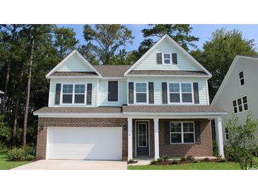 Charming two-story home boasts brick and siding exterior, attached garage, and manicured lawn at 750 Plumage Ct., Myrtle Beach, SC 29588