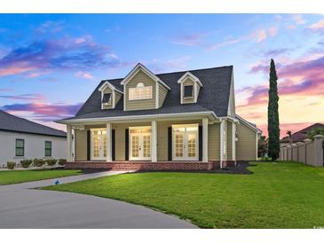 Charming home featuring a well-manicured lawn and a welcoming covered front porch with classic architectural details at 853 Bluffview Dr., Myrtle Beach, SC 29579