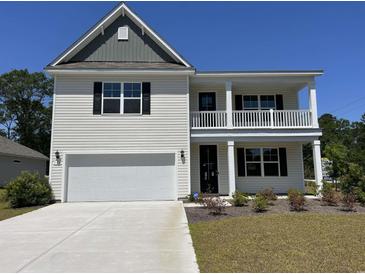 Charming two-story home with a covered porch, two-car garage, and landscaped front yard at 104 Fair Meadow Ct., Loris, SC 29569