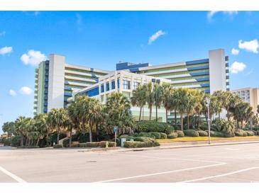 Bright and airy exterior view of a modern beachfront resort with lush palm trees and manicured landscaping at 1105 S Ocean Blvd. # 604, Myrtle Beach, SC 29577