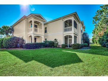 Beautiful two-story home with a well-maintained lawn and inviting balconies, showcasing its charming curb appeal at 123 Avian Dr. # 102, Pawleys Island, SC 29585