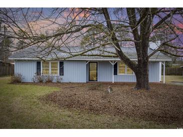 Charming single-story home with light blue siding, mature tree and metal roof at 125 Ole Cedar Ln., Conway, SC 29526