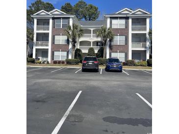 Well-maintained condo building with brick accents, balconies and plentiful parking on a bright day at 1298 River Oaks Dr. # 5-F, Myrtle Beach, SC 29579
