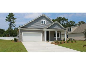 Charming home featuring horizontal siding, a pristine white garage door, and well-manicured green lawn at 1833 Hardwood Ct., Conway, SC 29526