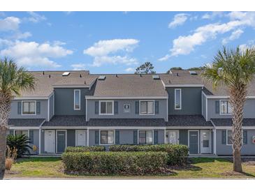 Inviting townhome featuring a neatly landscaped yard and a charming, symmetrical facade with gray tones at 1881 Colony Dr. # 8-S, Surfside Beach, SC 29575