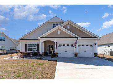 Charming one-story home features a two car garage, covered porch and beautifully landscaped front yard at 3074 Viceroy Loop, Little River, SC 29566