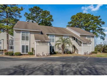 Charming exterior of condo featuring light siding, well-maintained landscaping, and convenient parking at 4494 Little River Inn Ln. # 2301, Little River, SC 29566