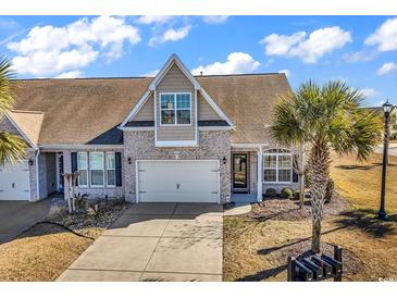 Charming home with a well-manicured lawn, tan brick, and an attached two-car garage at 5027 Prato Loop, Myrtle Beach, SC 29579