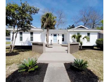 Charming white home with a modern boardwalk style front entrance and blue front door at 616 36Th Ave. S, North Myrtle Beach, SC 29582