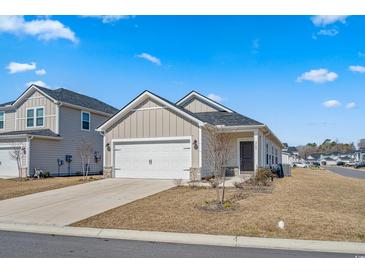 Charming single-Gathering home with a two-car garage, tidy landscaping, and a welcoming front porch at 8500 Dunes Point Way, Longs, SC 29568