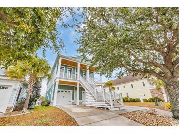 Charming, coastal style two-story home with a double garage and inviting staircase to covered porch at 949 Crystal Water Way, Myrtle Beach, SC 29579