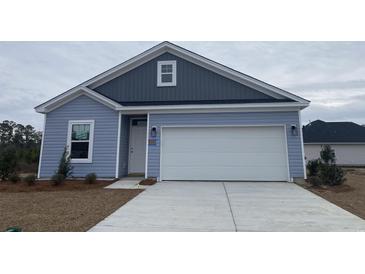 Charming single-story home featuring a two-car garage, light blue siding, and a well-maintained lawn at 969 Oak Hollow St., Longs, SC 29568