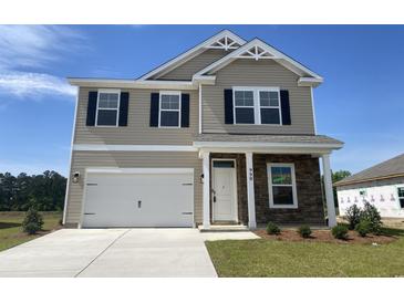 Charming two-story home with a two-car garage, stone accents, and a well-manicured lawn at 990 Oak Hollow St., Longs, SC 29568