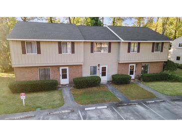 Inviting townhome with a brick and siding facade, mature landscaping, and parking available at 128 Beaver Pond Loop # 48, Pawleys Island, SC 29585