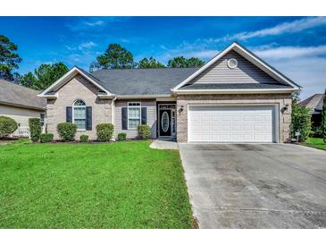 Charming one-story home featuring a manicured lawn, brick accents, and an attached two-car garage at 2749 Sanctuary Blvd., Conway, SC 29526