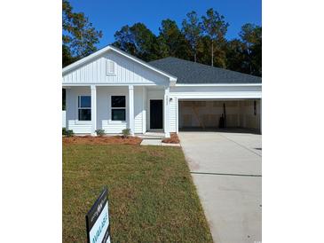 Charming single-story home featuring a black front door, attached garage, manicured lawn, and tasteful landscaping at 3065 Palma Way, Myrtle Beach, SC 29579