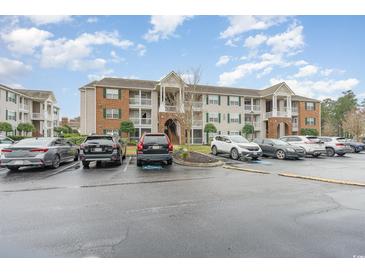 Apartment building with brick and siding, featuring balconies and ample parking at 3792 Hitchcock Way # 213, Myrtle Beach, SC 29577