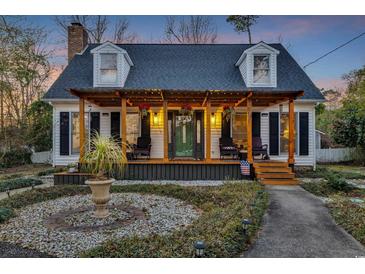 Charming home featuring a pergola covered front porch, dormer windows, and beautifully landscaped yard at 4405 Boxwood St., Myrtle Beach, SC 29577