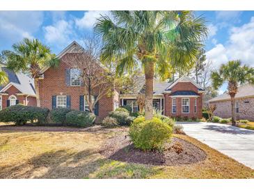 Charming brick home featuring a well-manicured lawn and mature palm trees in a desirable neighborhood at 5508 Leatherleaf Dr., North Myrtle Beach, SC 29582