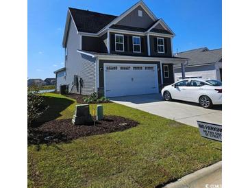 Charming two-story home featuring a two-car garage, manicured lawn, and contemporary design at 675 Cascade Loop, Little River, SC 29566