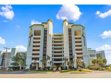 Beach House Resort exterior showcases parking garage, blue trim, and palm tree lined walkway in Myrtle Beach at 6804 N Ocean Blvd. # 533, Myrtle Beach, SC 29572