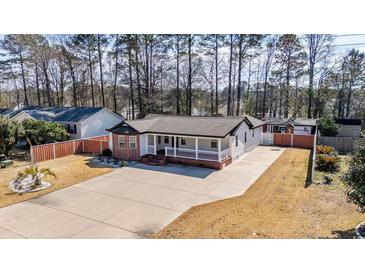 Charming home featuring a wide driveway and inviting front porch with brick accents and a well-maintained yard at 8533 Cedar Trace Dr., Myrtle Beach, SC 29588