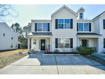 Charming townhome with a well-maintained lawn and inviting entrance with black shutters and a concrete driveway at 1144 Harvest Circle # 1144, Myrtle Beach, SC 29579