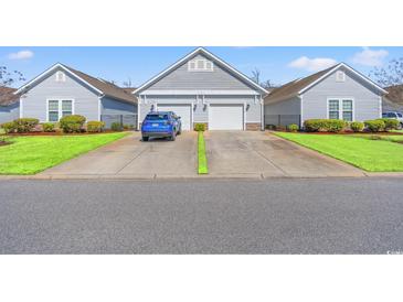 Charming one-story home with attached garages, manicured lawn, and a blue car in the driveway at 1541 Palmina Loop # C, Myrtle Beach, SC 29588