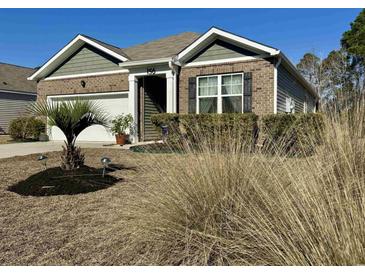 Charming brick home featuring a well-manicured lawn, a one car garage, and stylish shutters at 156 Legends Village Loop, Myrtle Beach, SC 29579