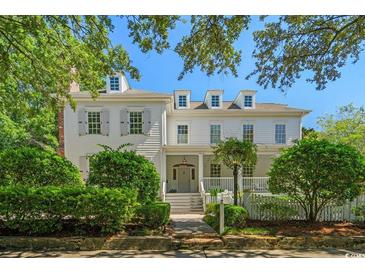 Charming white two-story home with gray shutters and a welcoming front porch surrounded by manicured landscaping at 201 Broad St., Georgetown, SC 29440