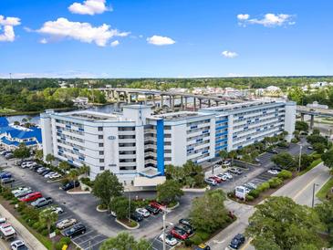 Beautiful exterior view of the condominium complex with ample parking and lush landscaping at 2100 Sea Mountain Hwy. # 122, North Myrtle Beach, SC 29582