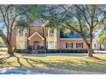 Charming two-story brick home with a well-manicured lawn and mature shade trees at 268 Wraggs Ferry Rd., Georgetown, SC 29440