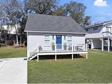 Charming beach house with a cozy front porch, steps, and lush green lawn at 306 Oak Lake Circle, North Myrtle Beach, SC 29582