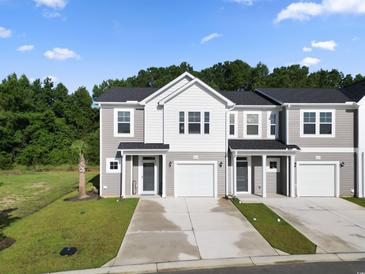 Charming townhouse with gray siding, a one-car garage, and a well-manicured lawn at 315 Sandridgebury Dr. # 70, Little River, SC 29566