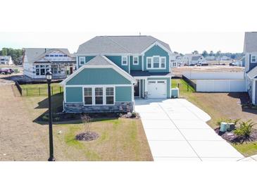 Charming two-story home with blue siding, stone accents, manicured lawn, and a pristine driveway at 511 Rose Fountain Dr., Myrtle Beach, SC 29579