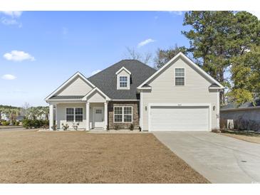 Charming home featuring a two-car garage, stone accents, manicured lawn, and a classic architectural design at 547 Bucks Trail, Longs, SC 29568