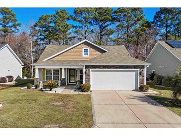 Charming single story home with a stone and shake exterior, a well-manicured lawn, and an attached two car garage at 725 Old Castle Loop, Myrtle Beach, SC 29579