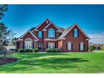 Beautiful brick two-story home with manicured lawn and lush landscaping creating stunning curb appeal at 1585 Brookgreen Dr., Myrtle Beach, SC 29577