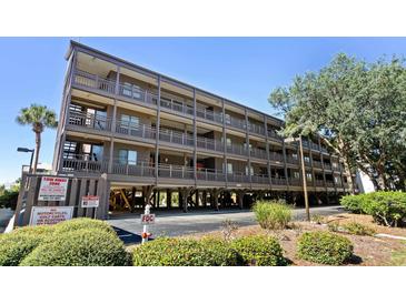 Multi-story condo building featuring covered parking, open balconies, and well-maintained landscaping at 207 3Rd Ave. N # 348, North Myrtle Beach, SC 29582