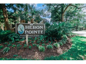 Attractive community entrance sign surrounded by lush greenery and colorful flowerbeds under a sunny sky at 223 Maisons Dr. # A8, Myrtle Beach, SC 29572