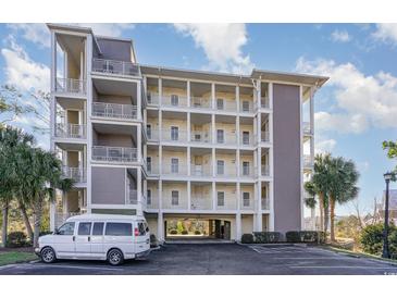 Exterior view of a multi-story building showcasing its balconies, parking, and architectural design elements at 233 Banbury Ln. # 302, Little River, SC 29566