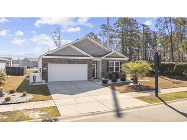 Charming one-story home with a brick facade, manicured landscaping, and a two-car garage on a sunny day at 2815 Eclipse Dr., Myrtle Beach, SC 29577