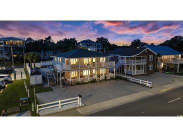 Charming two-story beach home featuring double balconies and ample parking space at twilight at 1420 S Ocean Blvd., North Myrtle Beach, SC 29582