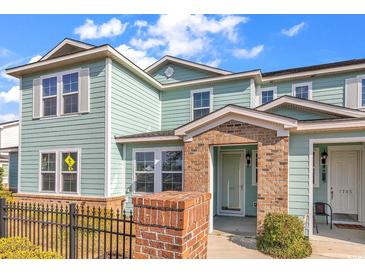Charming townhome with a brick entryway, light teal siding, black railing and a well-maintained landscape at 1749 Culbertson Ave. # 1749, Myrtle Beach, SC 29577