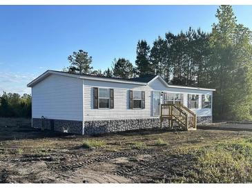 Charming single-story home with white siding, black shutters, and a stone foundation at 3685 Nichols Hwy., Aynor, SC 29511