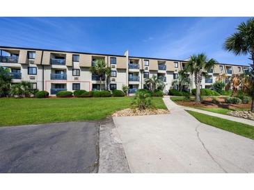 Well-maintained condo complex with manicured lawn, shrubbery, walkway, and mature palm trees at 405 21St Ave. S # 1-O, North Myrtle Beach, SC 29582
