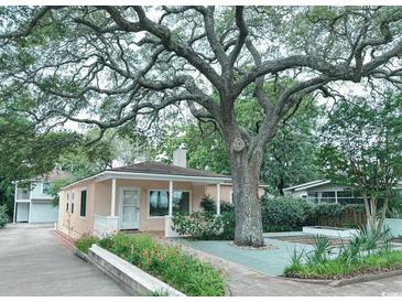 Charming single-story home with a well-maintained lawn and beautiful, mature shade tree at 413 30Th Ave. N, Myrtle Beach, SC 29577