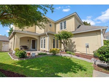 Inviting two-story home with manicured lawn, mature trees, and charming front porch at 4306 Windy Heights Dr., North Myrtle Beach, SC 29582