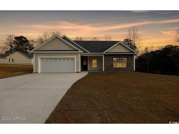 Charming single-Gathering home with a two-car garage and manicured lawn at dusk at 1107 Haden Place, Calabash, NC 28467